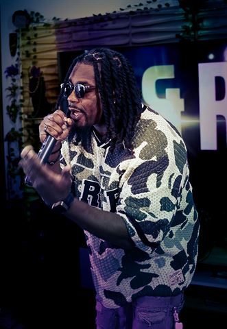 2Plby$ at RRL 2026, braids and sunglasses in camo mesh jersey performing before glowing letter sign