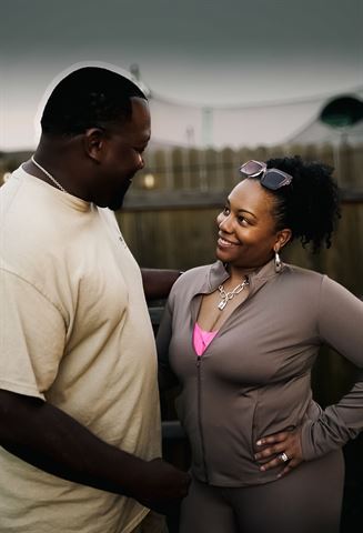 Behind the scenes at RRL 2026, pair smiling at each other by the wooden fence at dusk