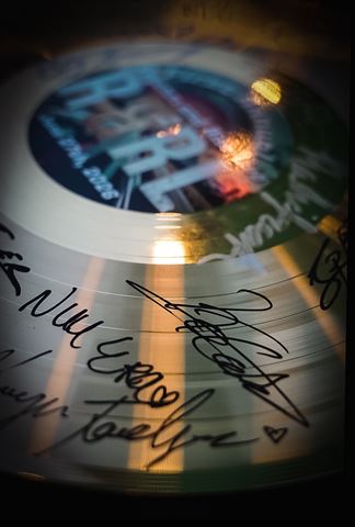 Behind the scenes at RRL 2026, gold record award covered in artist signatures in warm light