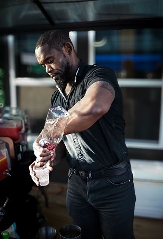 Behind the scenes at RRL 2026, bartender pouring a drink at the outdoor bar setup