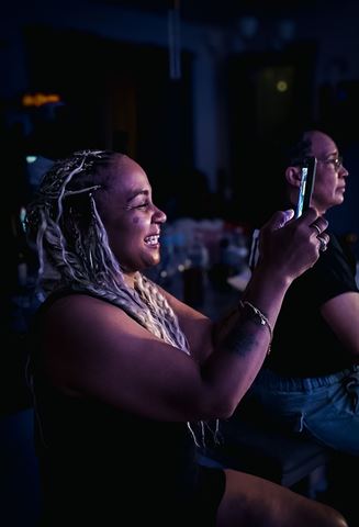 Behind the scenes at RRL 2026, guests filming the show on a phone in the dim room