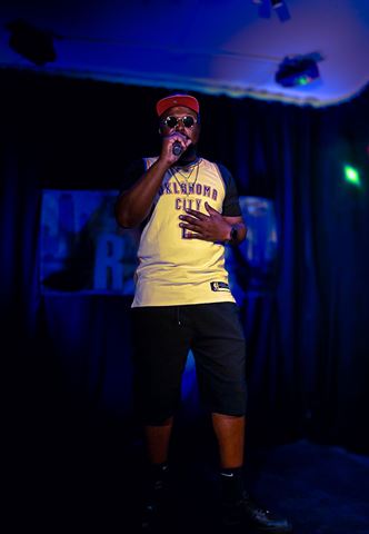 Big Tree #4real at RRL 2026, full-length in red cap and Oklahoma City jersey before the blue-lit curtain backdrop