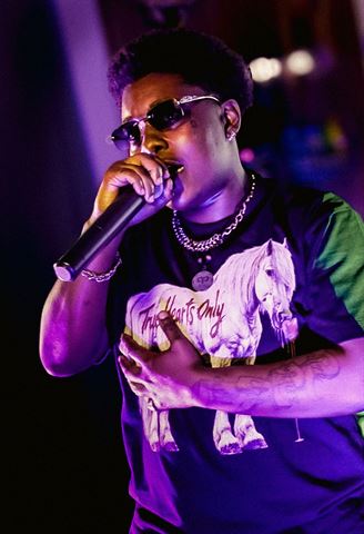 Booga Brim at RRL 2026, in slim sunglasses and chain rapping into the mic with hand on chest