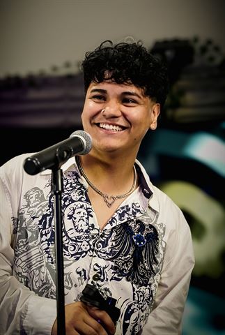 Evver The Thinker at RRL 2026, smiling curly-haired singer in white patterned shirt behind the mic stand