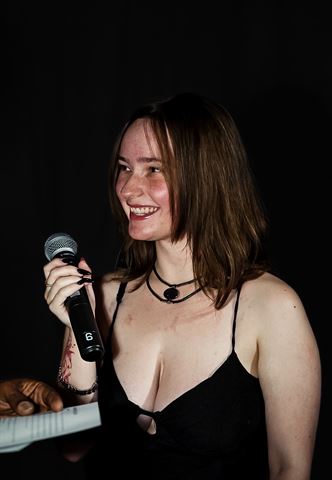 Kameryn Taelyr at RRL 2026, smiling in black dress holding the mic