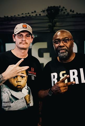 Kocain and Mr Durite at RRL 2026, two men posing with hand signs by the stage