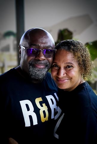 Mr and Mrs Durite, smiling couple in matching black R&RL shirts posing cheek to cheek indoors