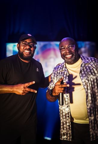 Mr Durite and the Mayor, two smiling men posing together before the blue-lit screen