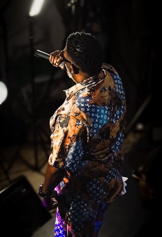 Mr Shorts, overhead view in monogram-print shirt performing amid the stage lighting rigs