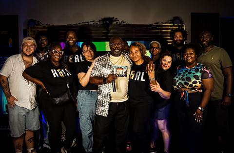 RRL Crew, the crew in matching R&RL shirts posing together before the colorful screen
