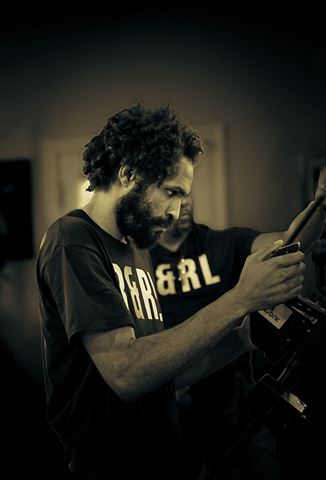 RRL Crew, crew member in R&RL shirt adjusting a camera rig in warm indoor light