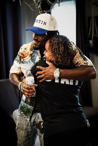 Tay No Tee at RRL 2026, artist in blue-and-cream cap and painted shirt hugging smiling crew member