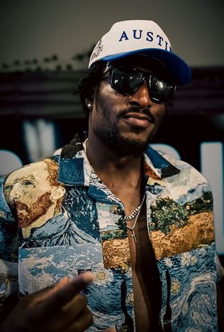 Tay No Tee at RRL 2026, in Van Gogh tapestry shirt, sunglasses and white Austin cap posing at night