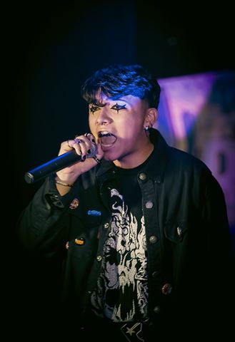 Untitled Flows at RRL 2026, star eye makeup, singing open-mouthed into the mic in blue and purple light
